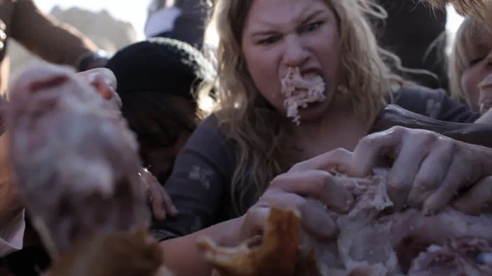 Une femme blonde mange de la viande crue dans une scène du film Rubber.