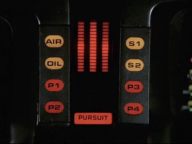Interface de communication du véhicule K.I.T.T., avec des boutons étiquetés AIR, OIL, P1, P2, S1, S2, P3, P4 et un indicateur lumineux PURSUIT.