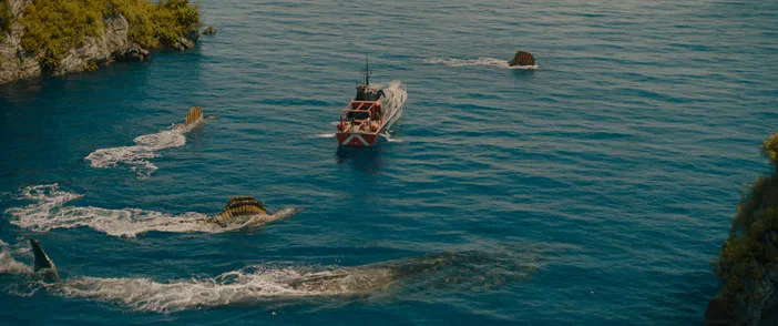 Dans Jurassic World Rebirth, un Mosasaurus et un Spinosaurus chassent ensemble une proie près d'un bateau.